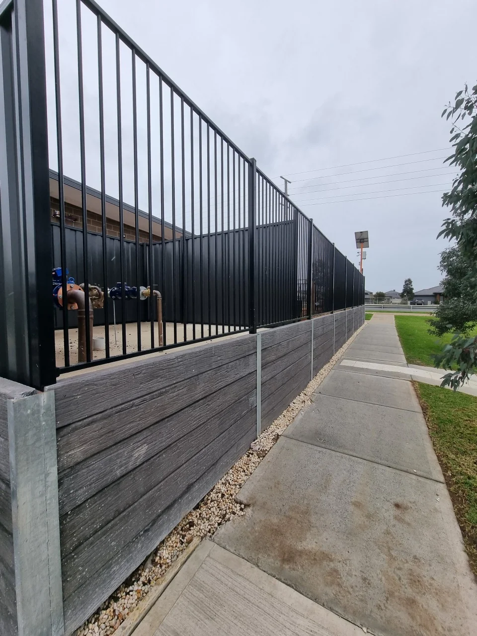 Ashwood timber-look concrete sleeper wall with tubular steel fencing along the Derrimut footpath