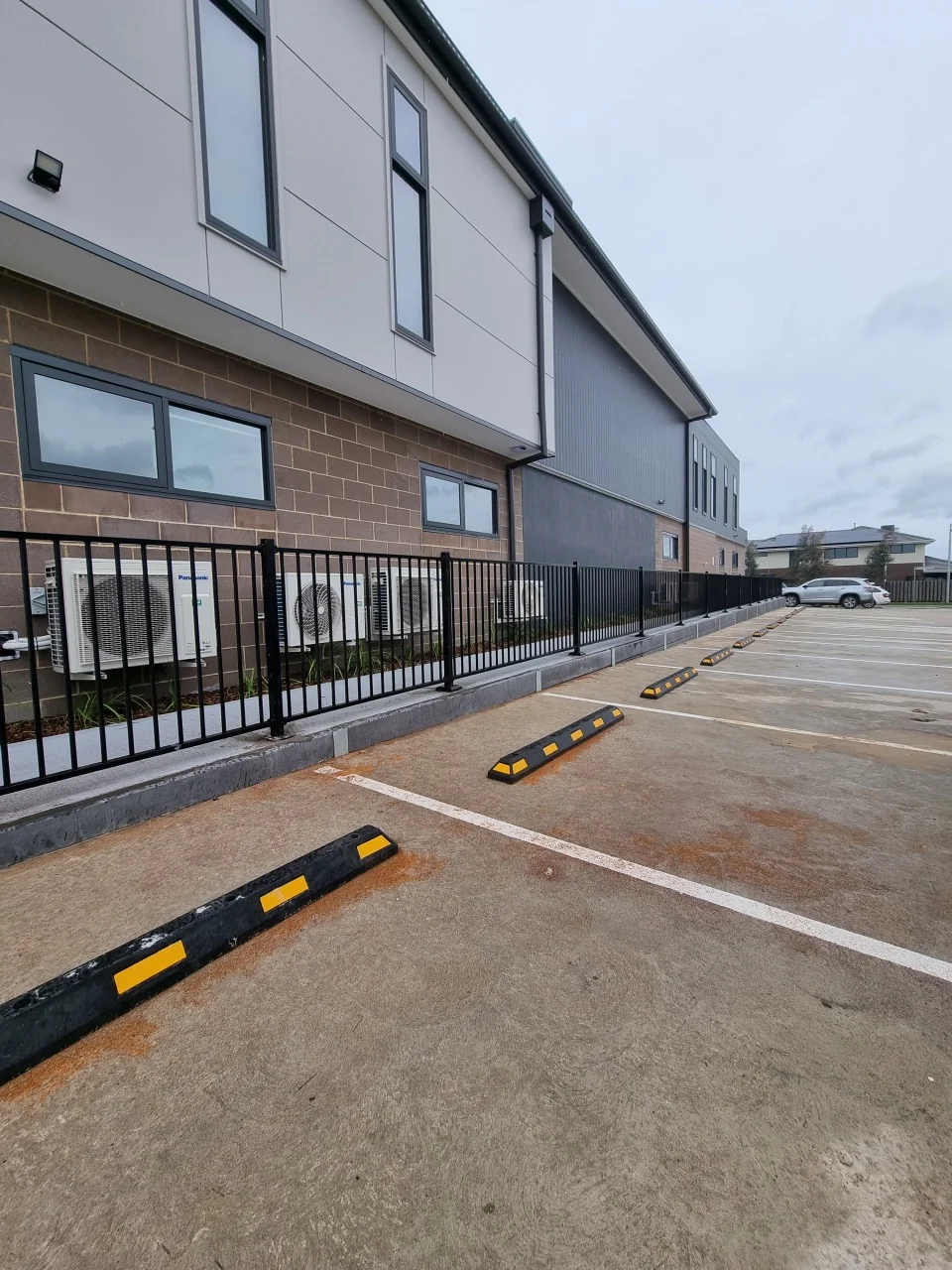 Concrete sleeper wall and tubular steel fence along the Derrimut childcare car park