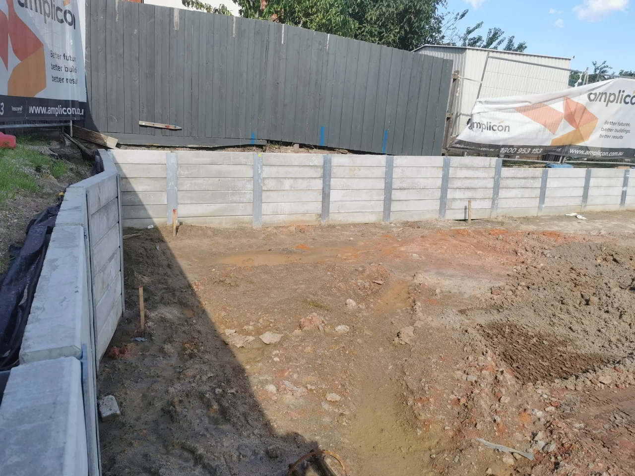 Concrete sleeper retaining wall corner beside the boundary fence at the Huntingdale project