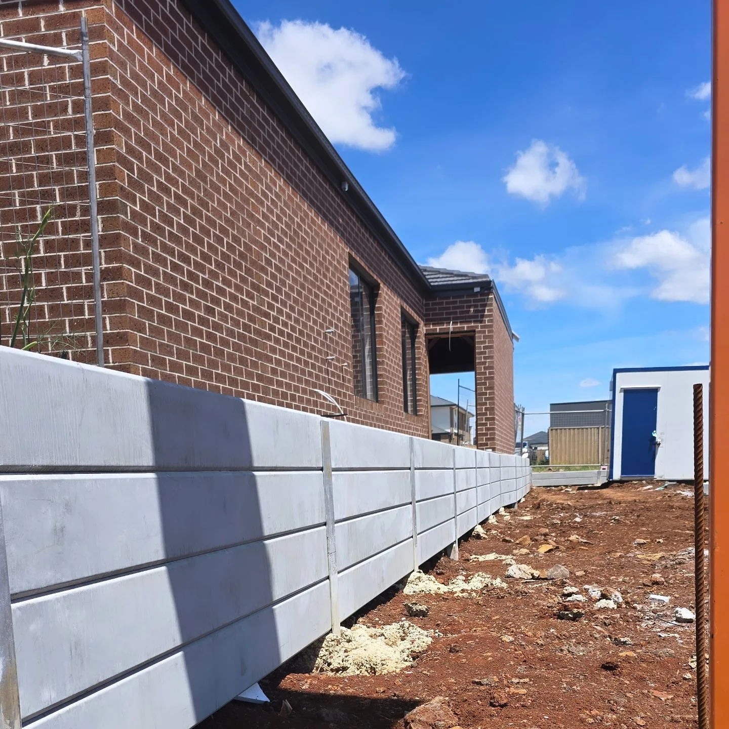 Concrete sleeper retaining wall along the brick building at Rockbank Childcare Centre